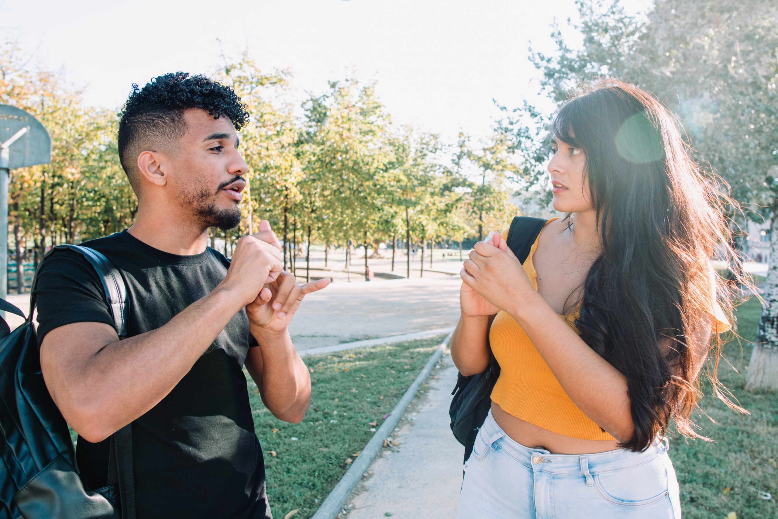 Sign language: 2 hispanic and african american student friends deaf talking with nonverbal communication.