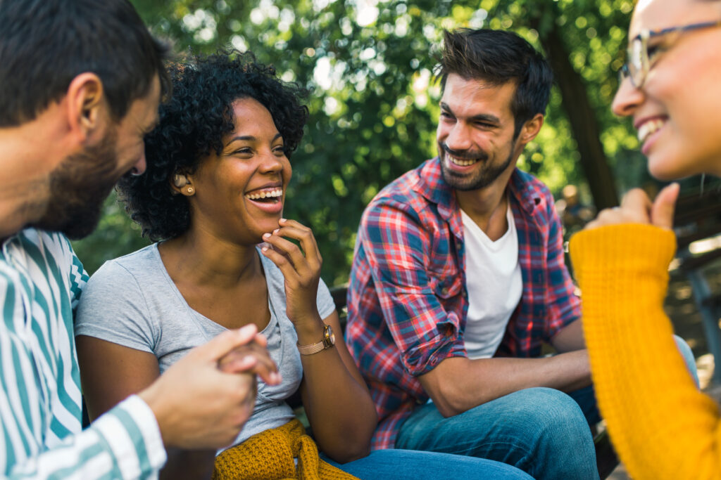 Woman with hearing aid having fun with her friends in the park